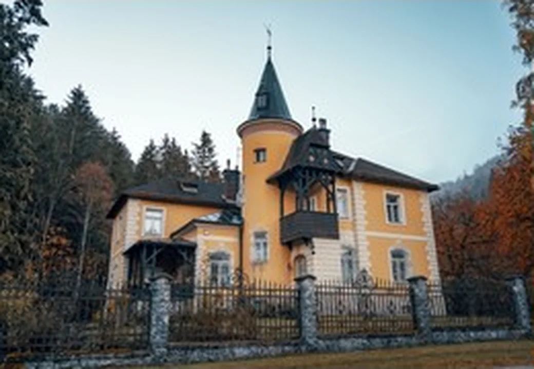 Historisches gelbes Wohnhaus mit Turm und Vorgarten